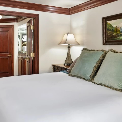 a bed with pillows and a lamp in a room
