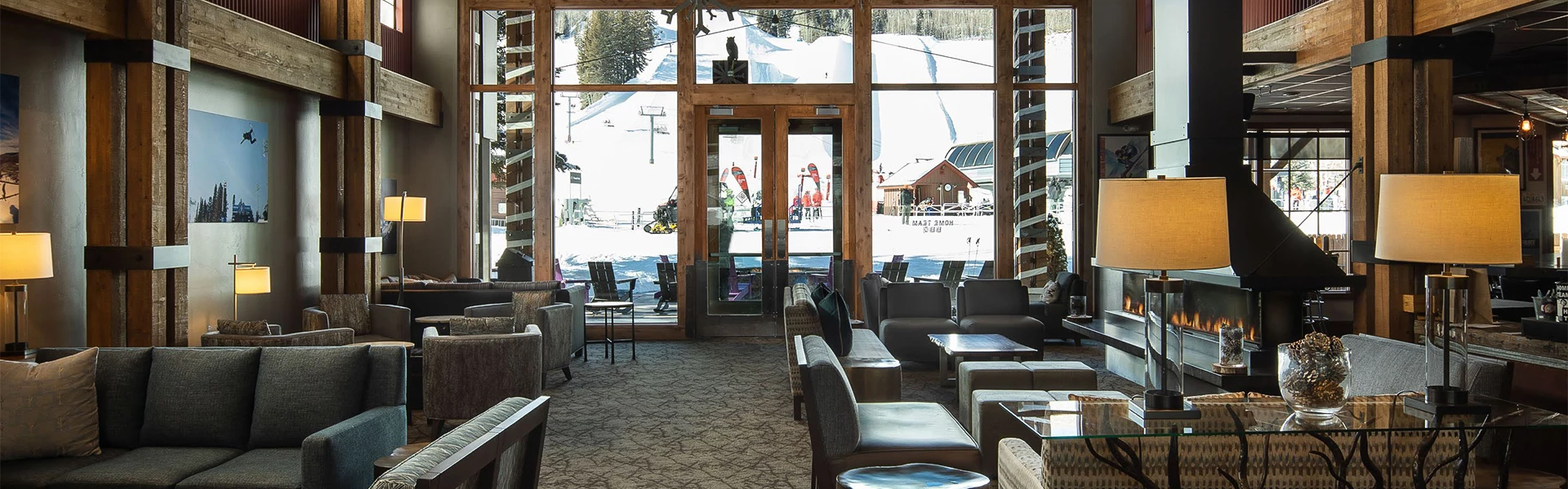 a room with chairs and tables and a snow covered mountain