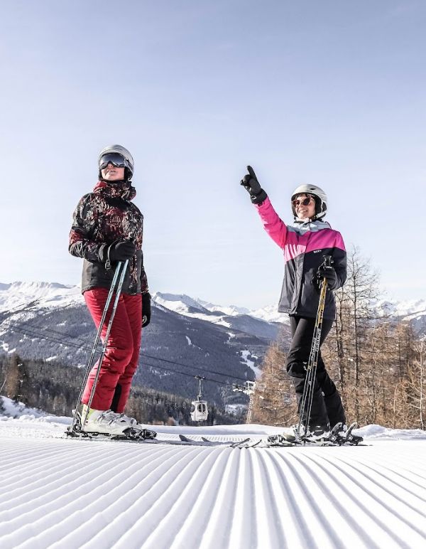 two women on skis on a snowy mountain