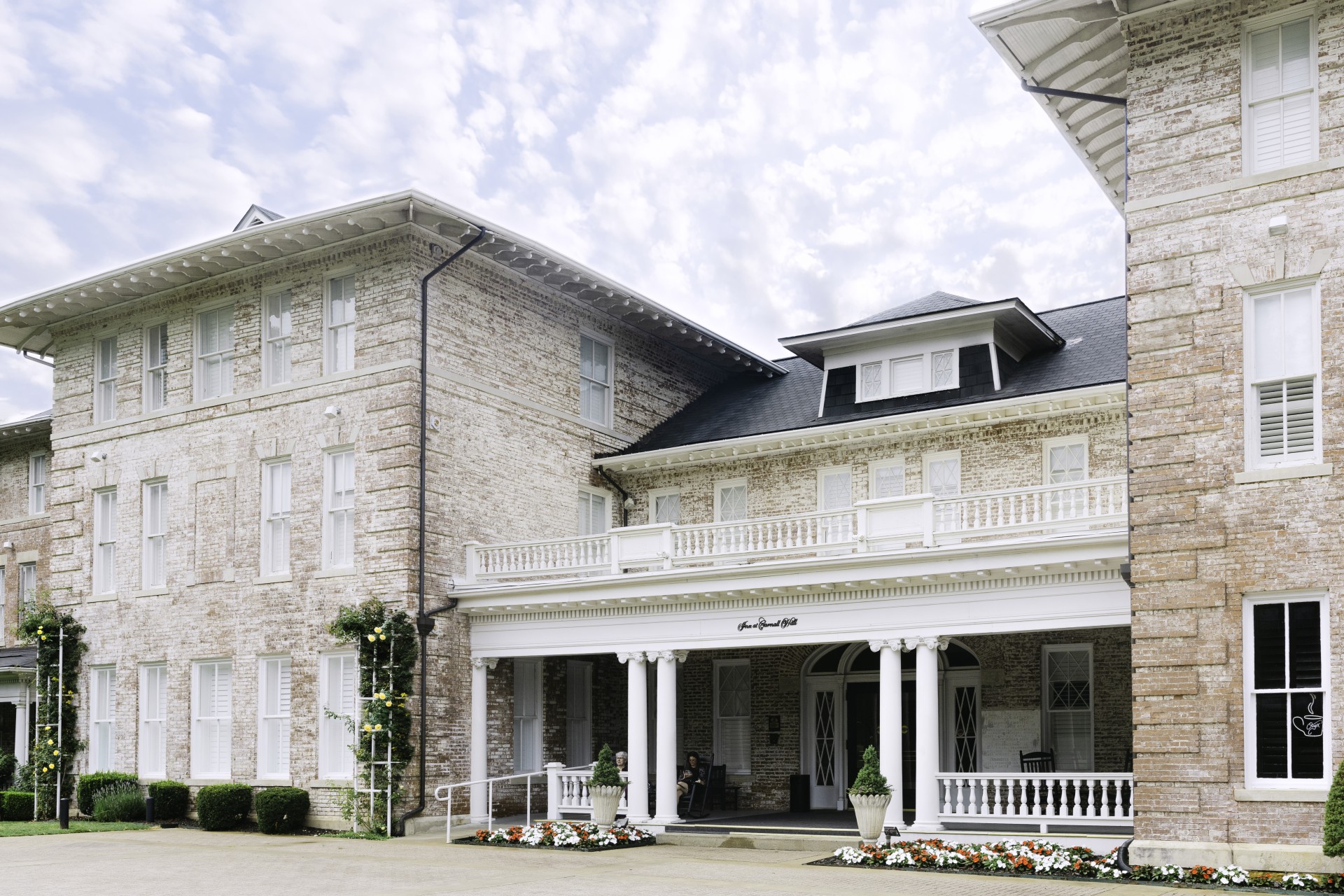 a large brick building with columns and a porch