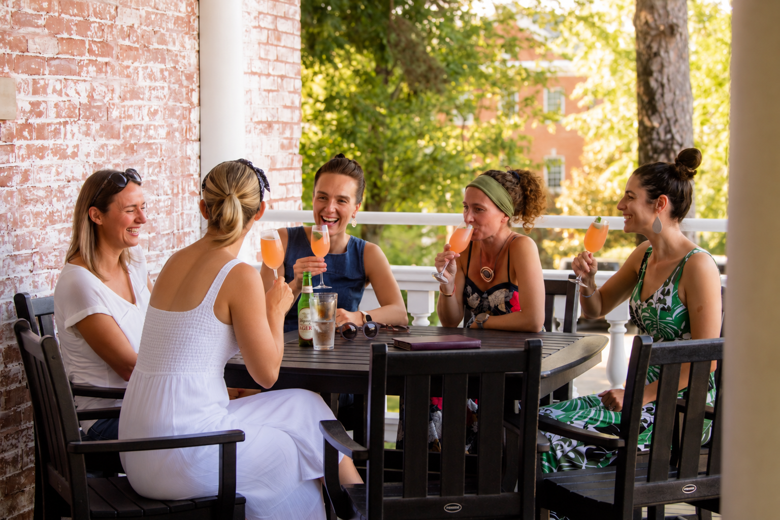 a group of women sitting at a table drinking drinks