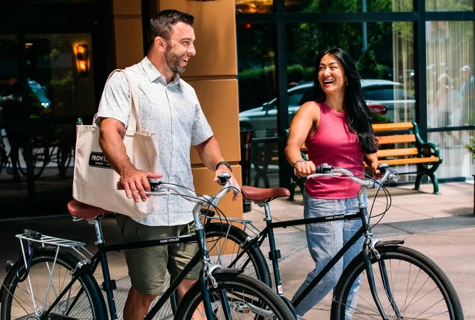 a man and woman walking with bicycles