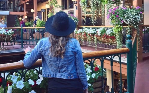 a woman in a hat looking at flowers