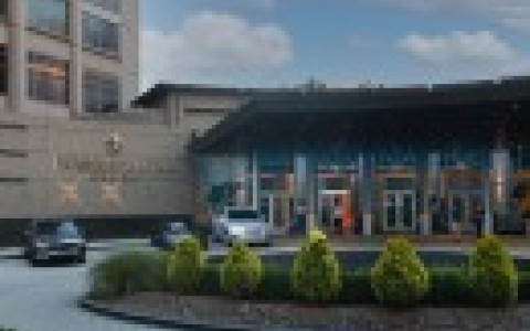 a building with a circular driveway and cars parked in front of it