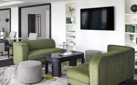 a living room with green couches and a black coffee table