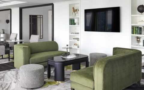 a living room with green couches and a black coffee table