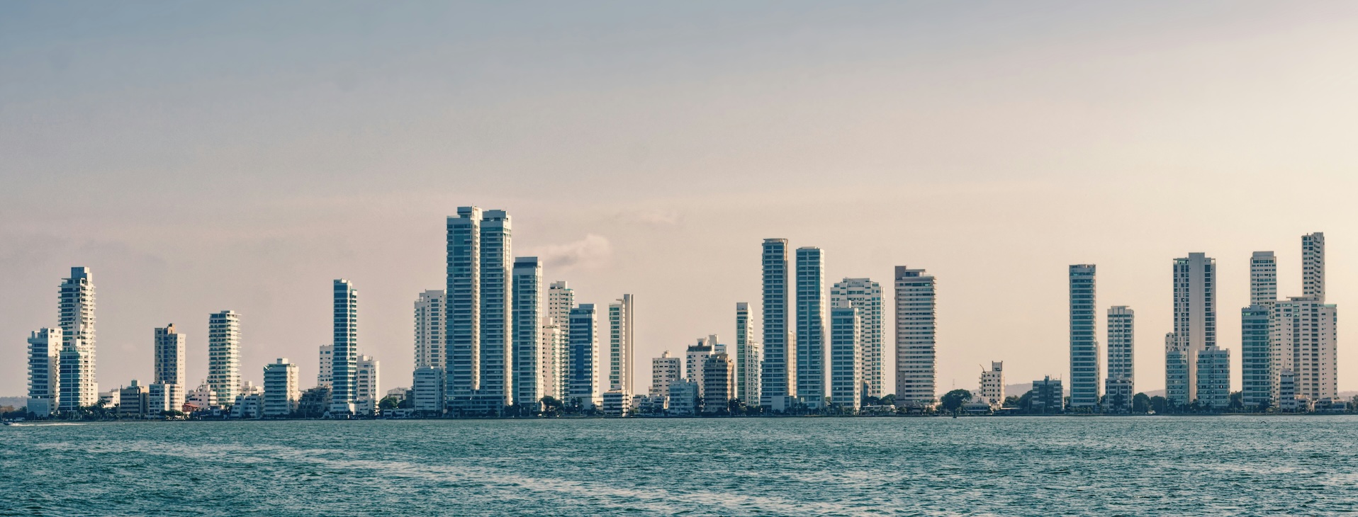 a city skyline with tall buildings and a body of water