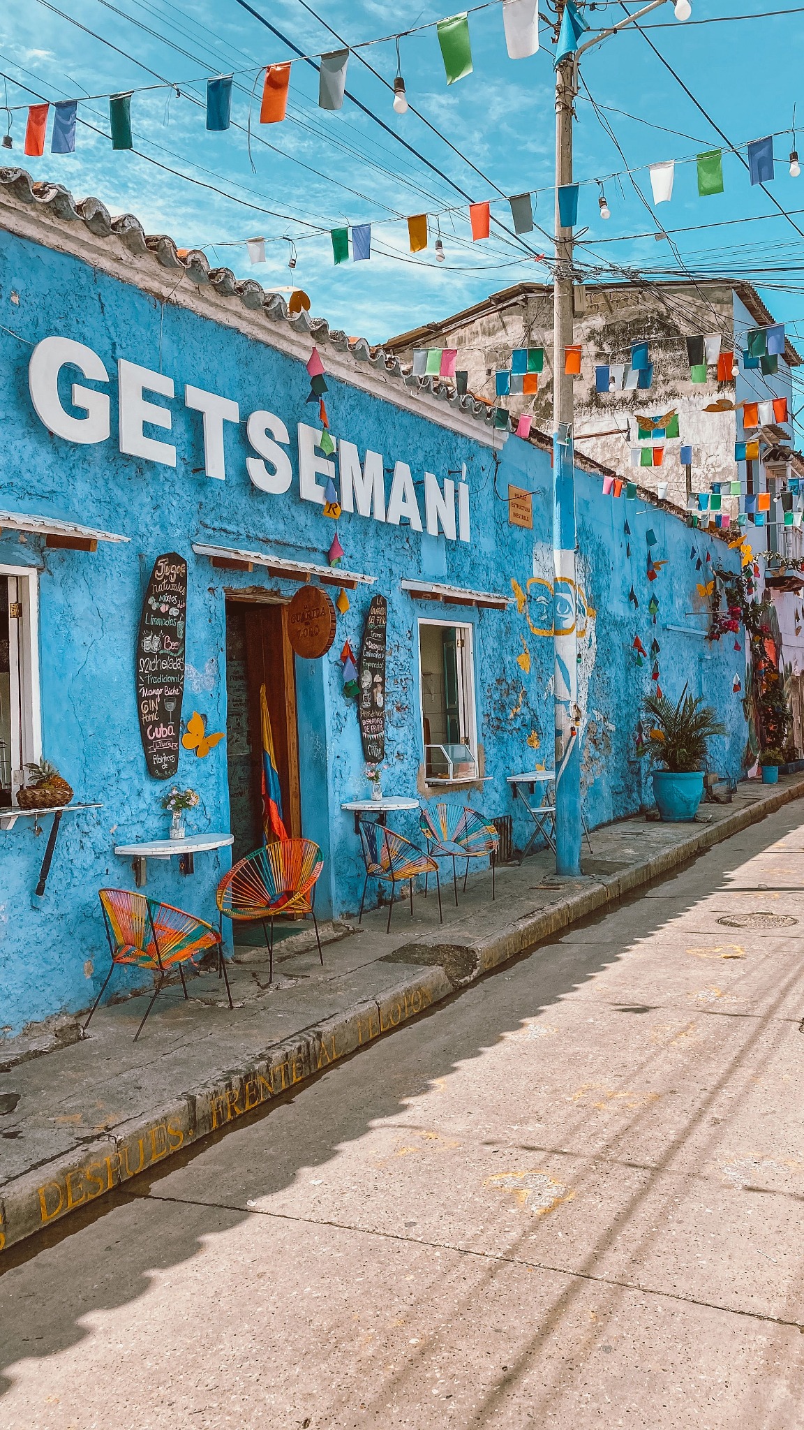 a blue building with chairs and flags
