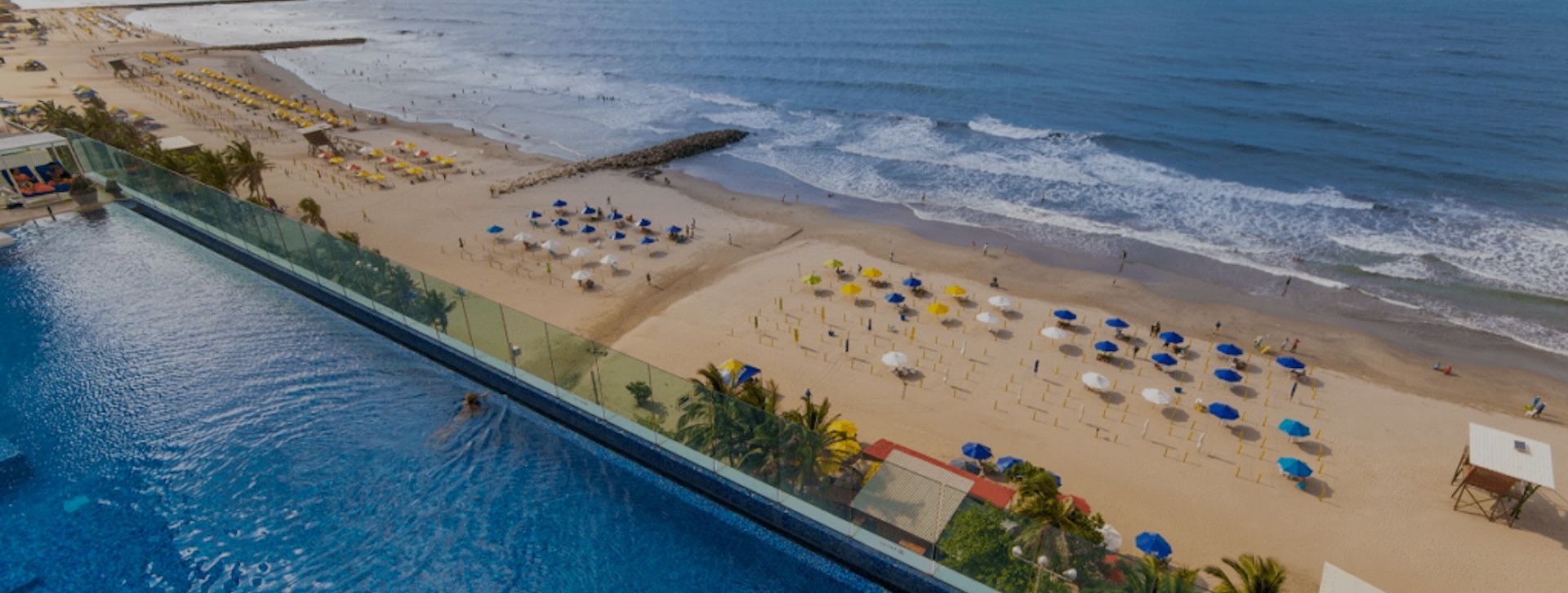 a beach with umbrellas and a pool