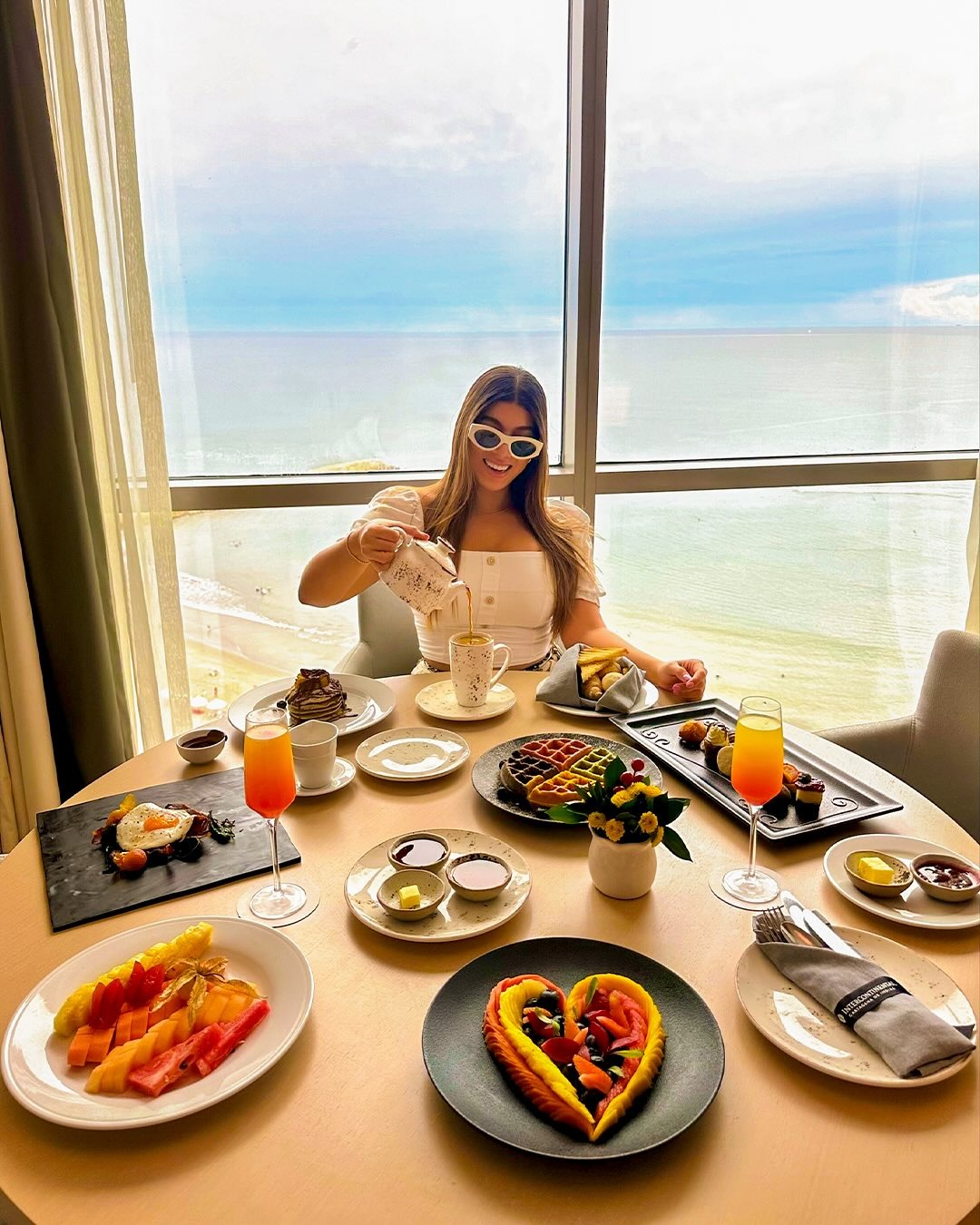 a woman sitting at a table with food on it
