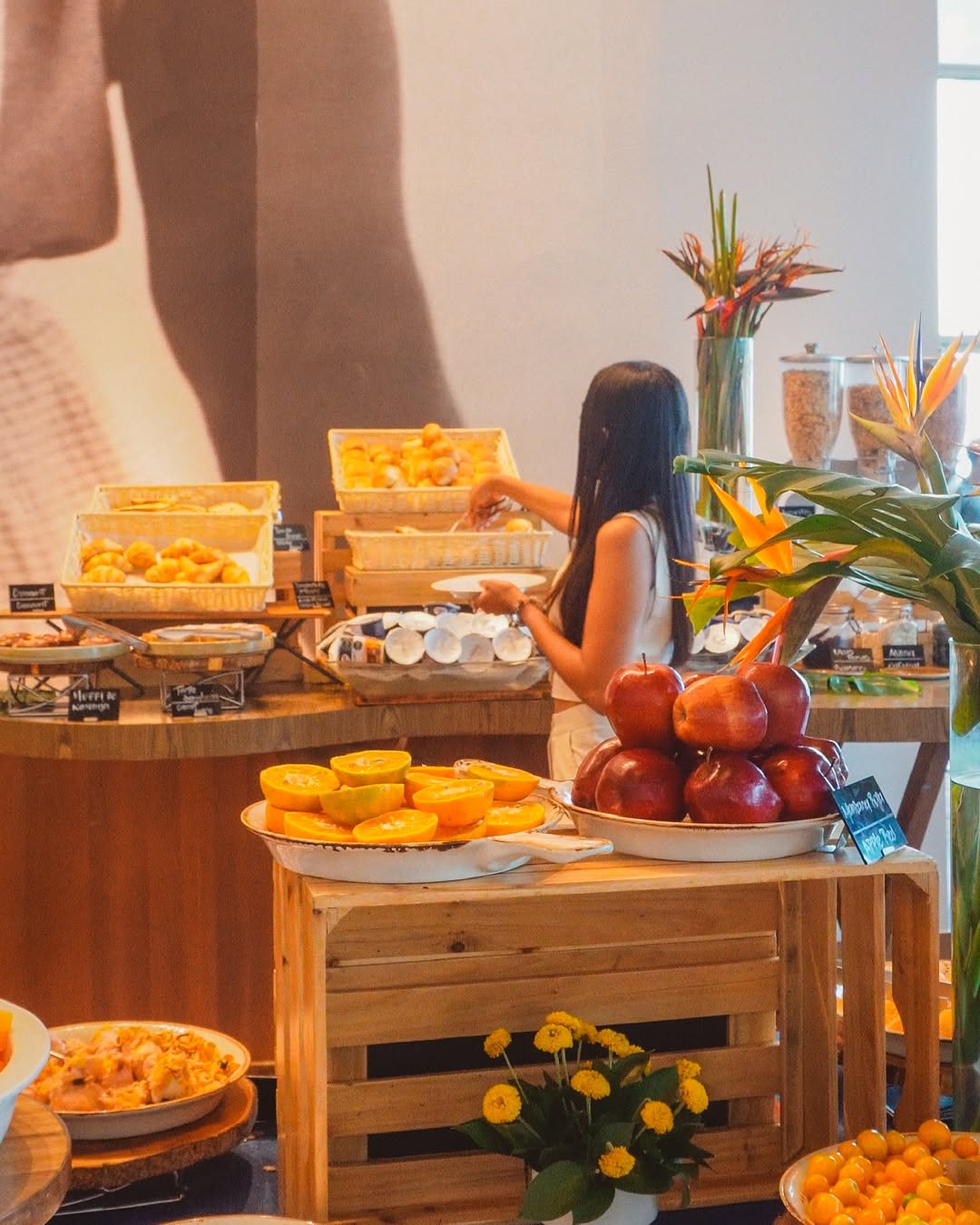 a woman standing at a table with fruit