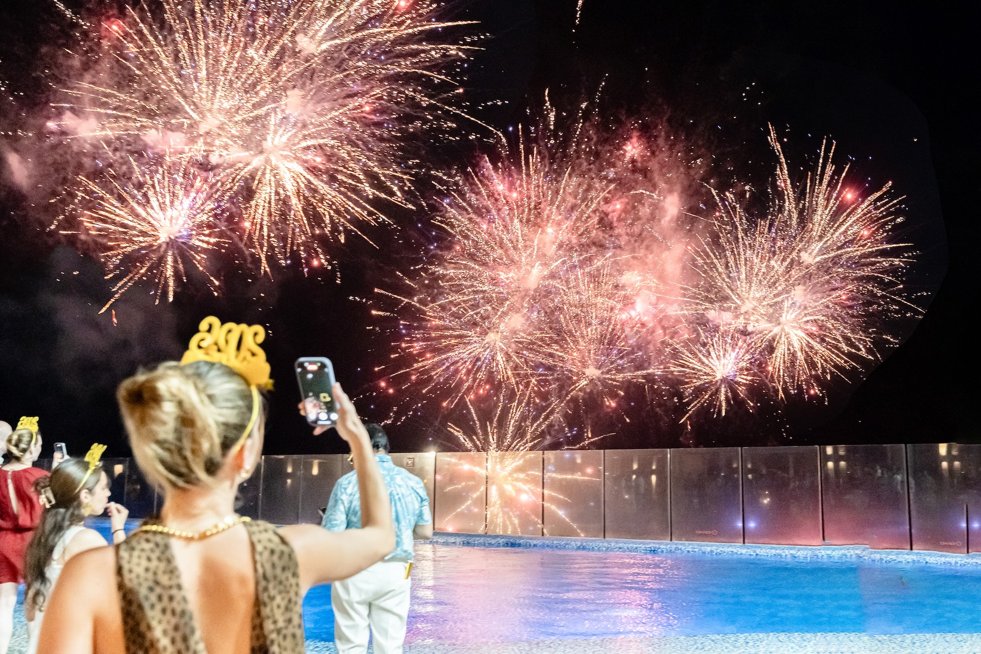 a woman taking a picture of fireworks
