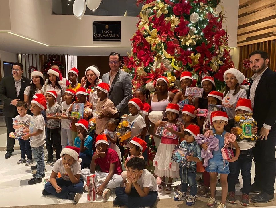 a group of people posing for a photo in front of a christmas tree