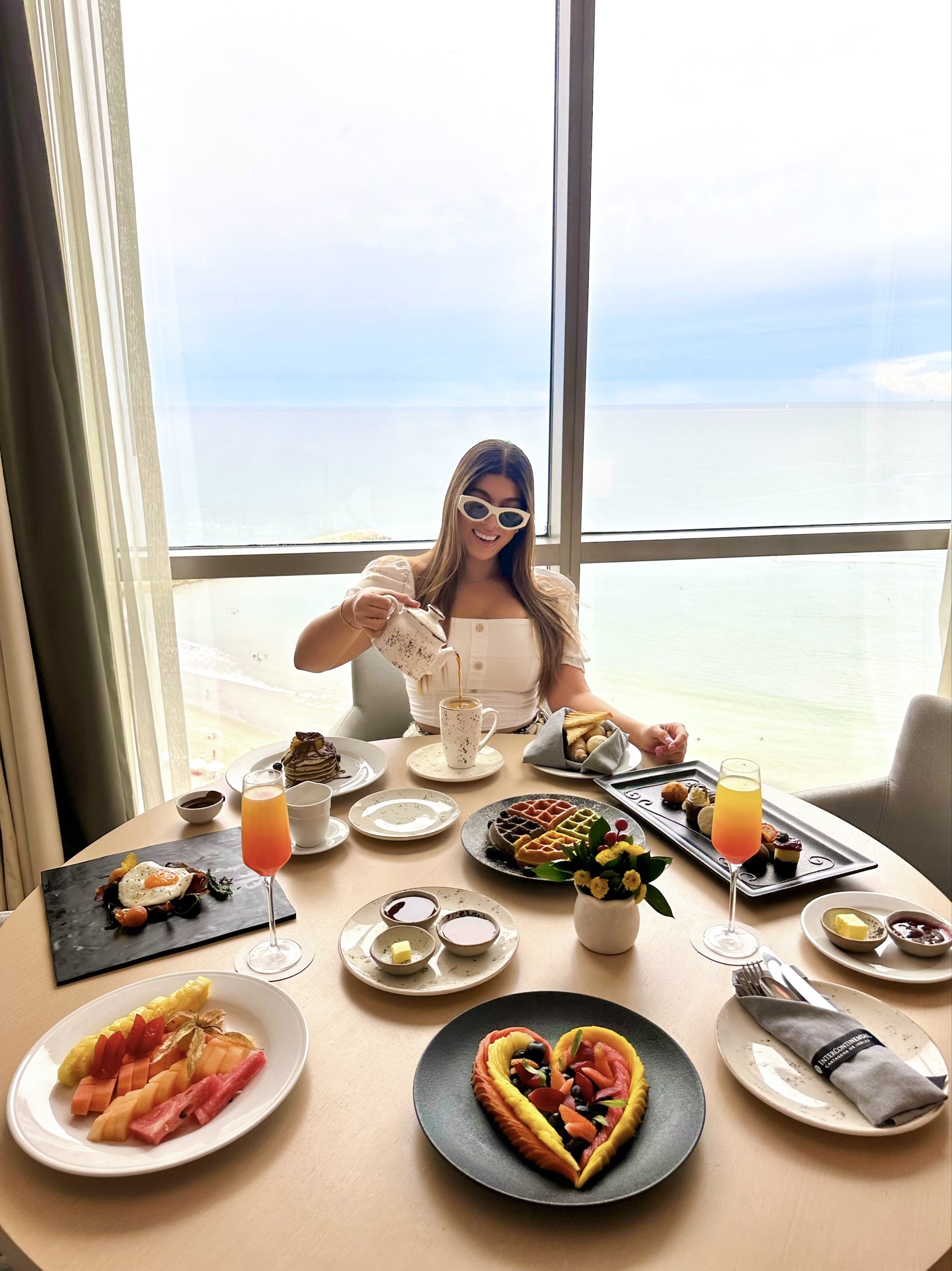 a woman sitting at a table with food on it