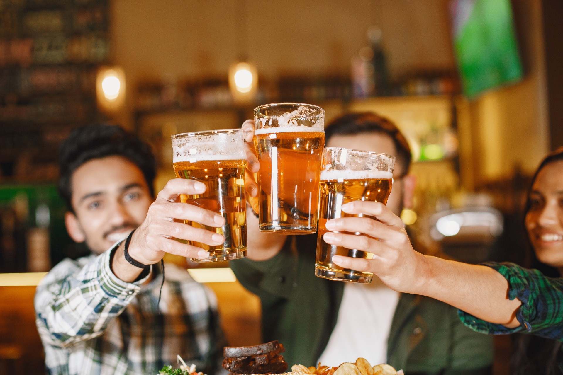a group of people holding up glasses of beer