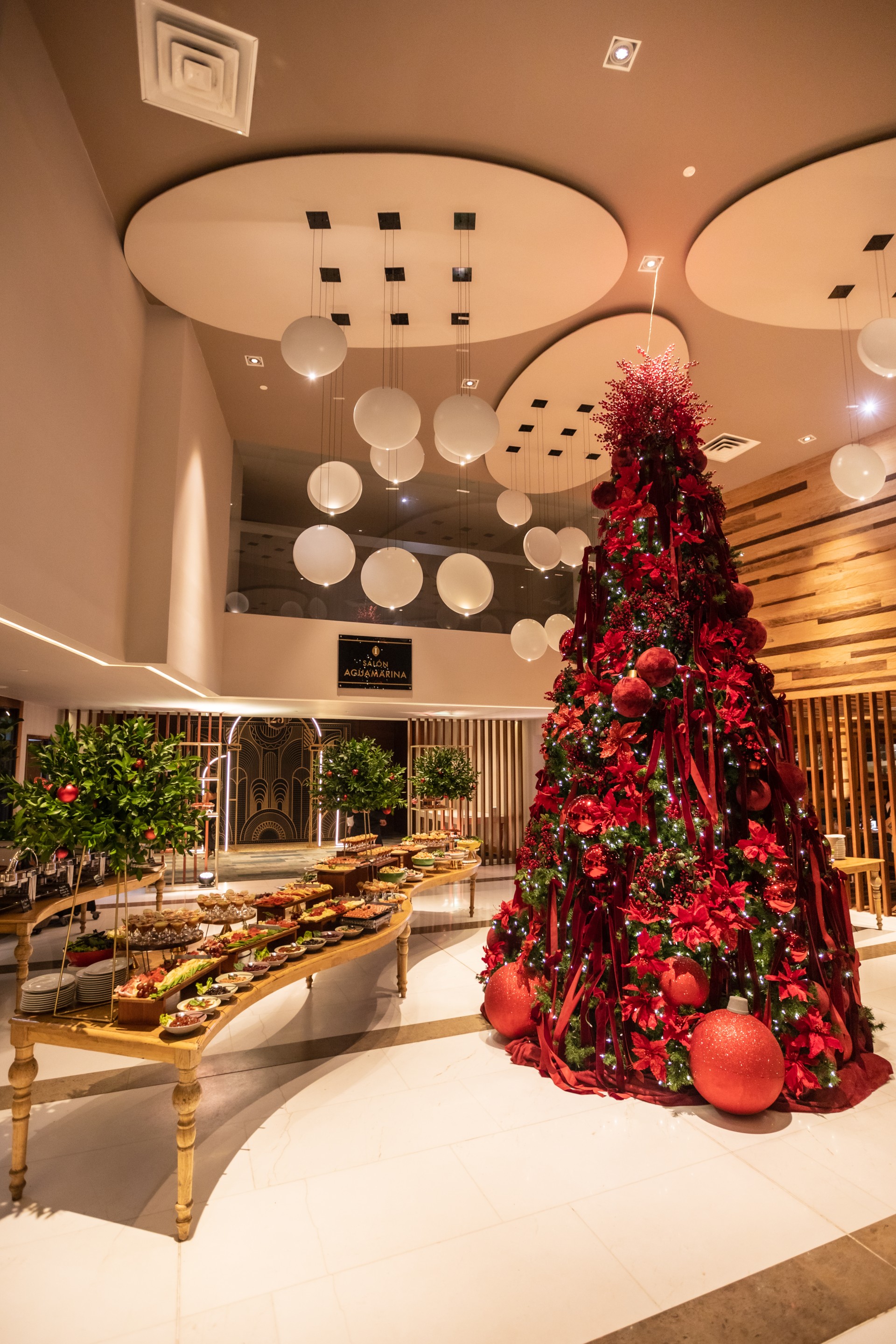 a large christmas tree in a room with white balls and lights
