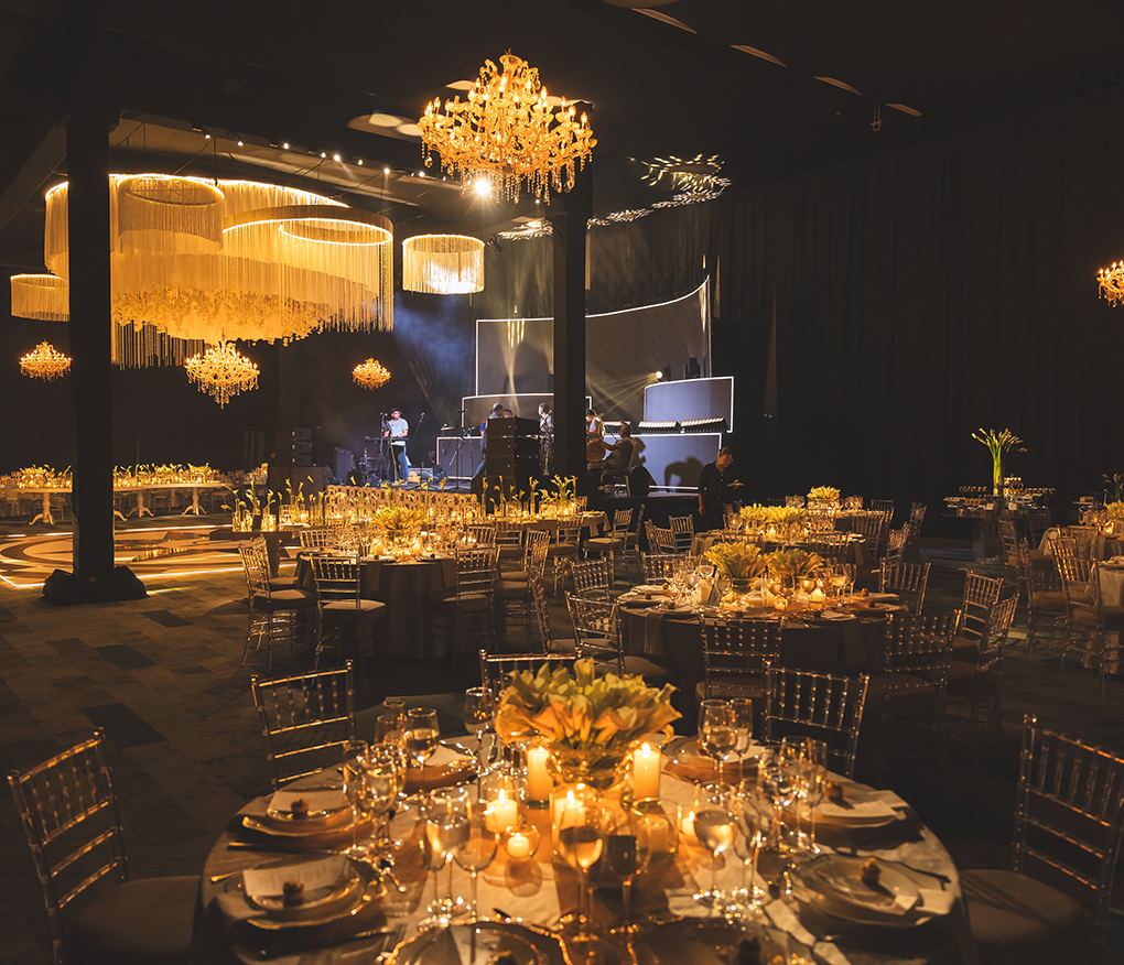 a group of tables with candles and chandeliers in a dark room