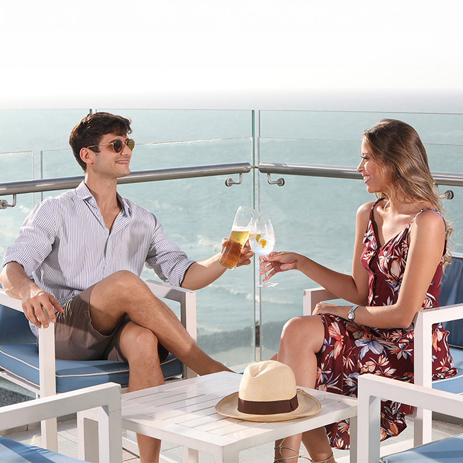 a man and woman sitting at a table with drinks