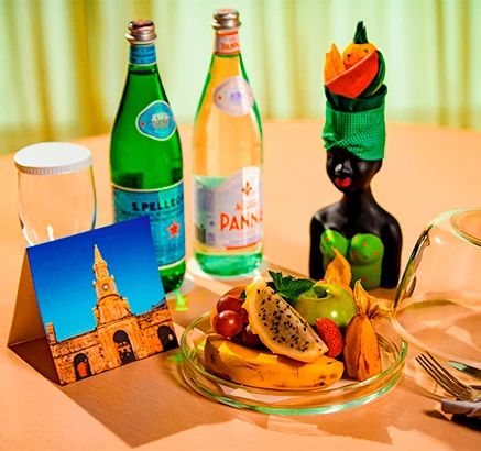 a table with a plate of fruit and drinks