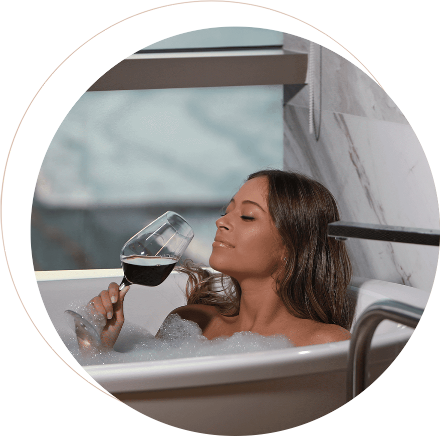 a woman in a bathtub drinking wine