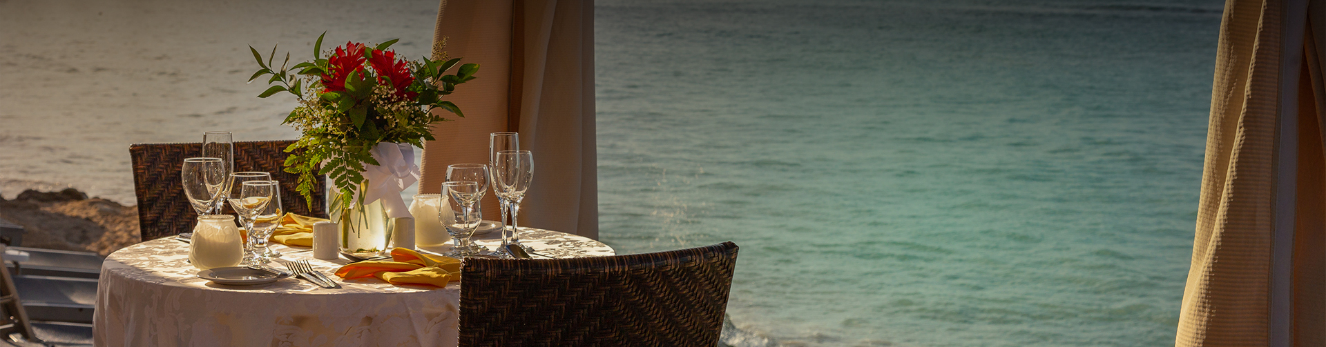 a table with wine glasses on it by the ocean