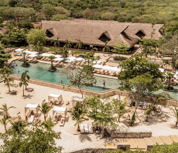 a pool with people in it surrounded by trees