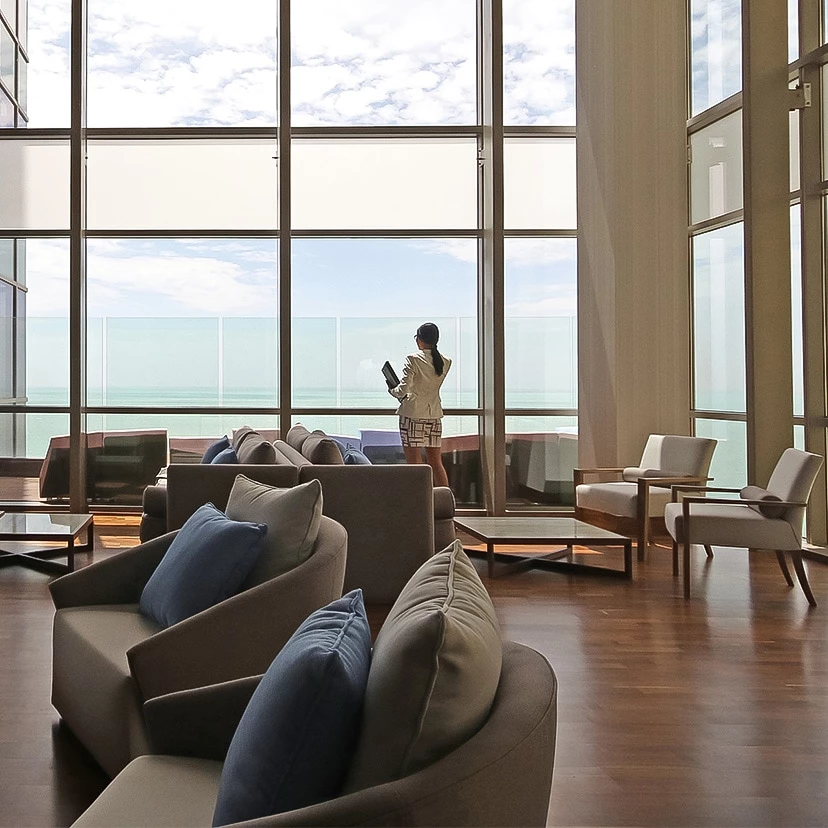 a person standing in a room with large windows