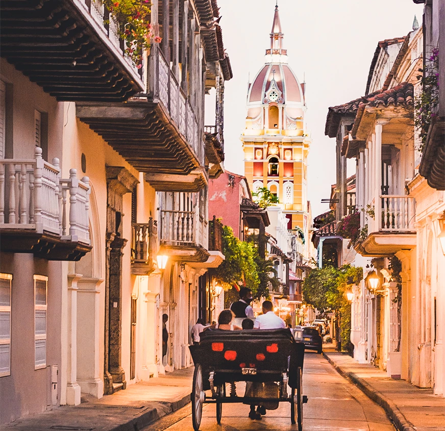 a couple of people sit in a carriage on a narrow street