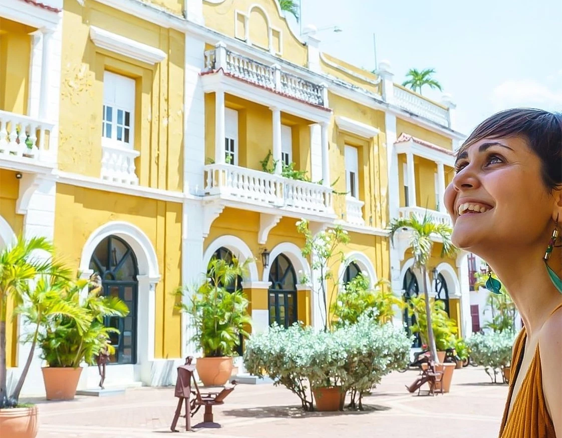 a woman smiling in front of a building