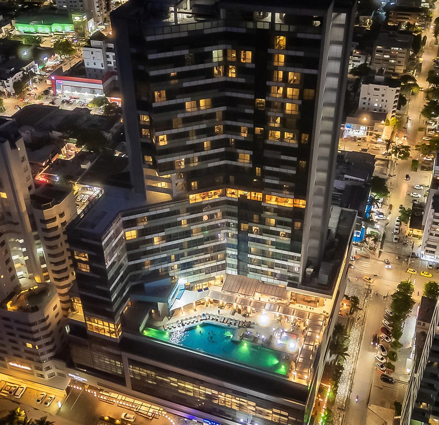 a building with a pool in the middle of a city at night