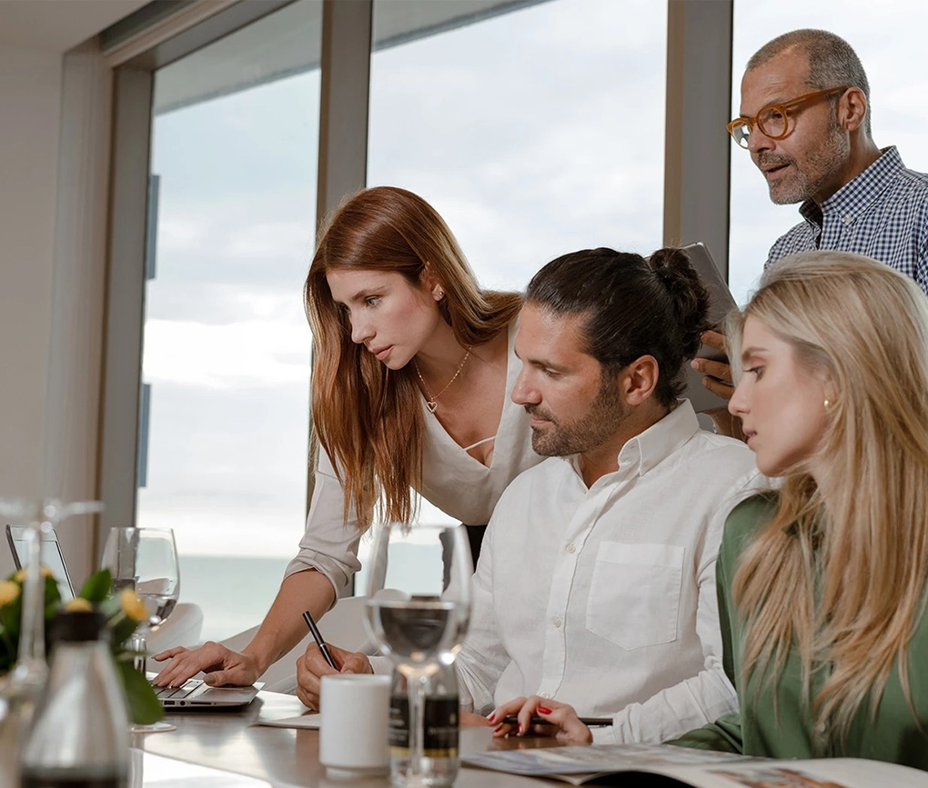 a group of people looking at a laptop