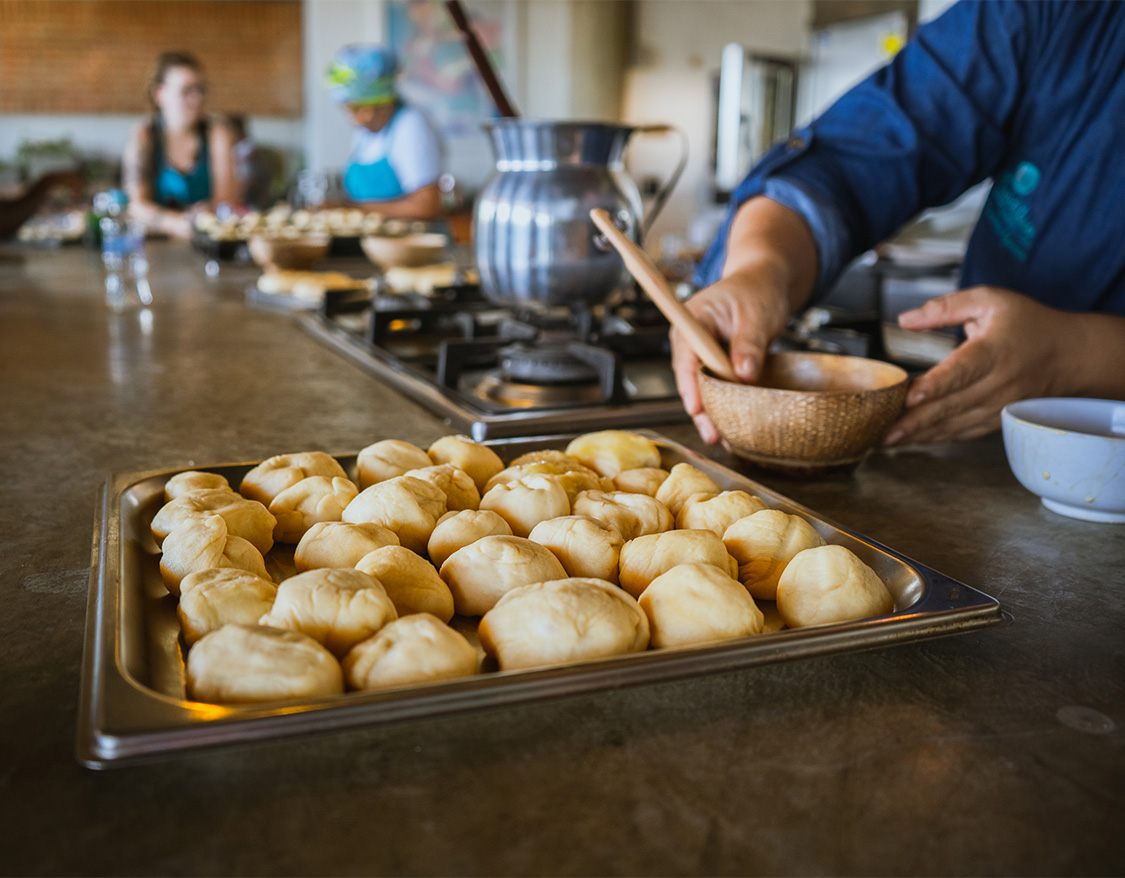 a person holding a bowl of dough