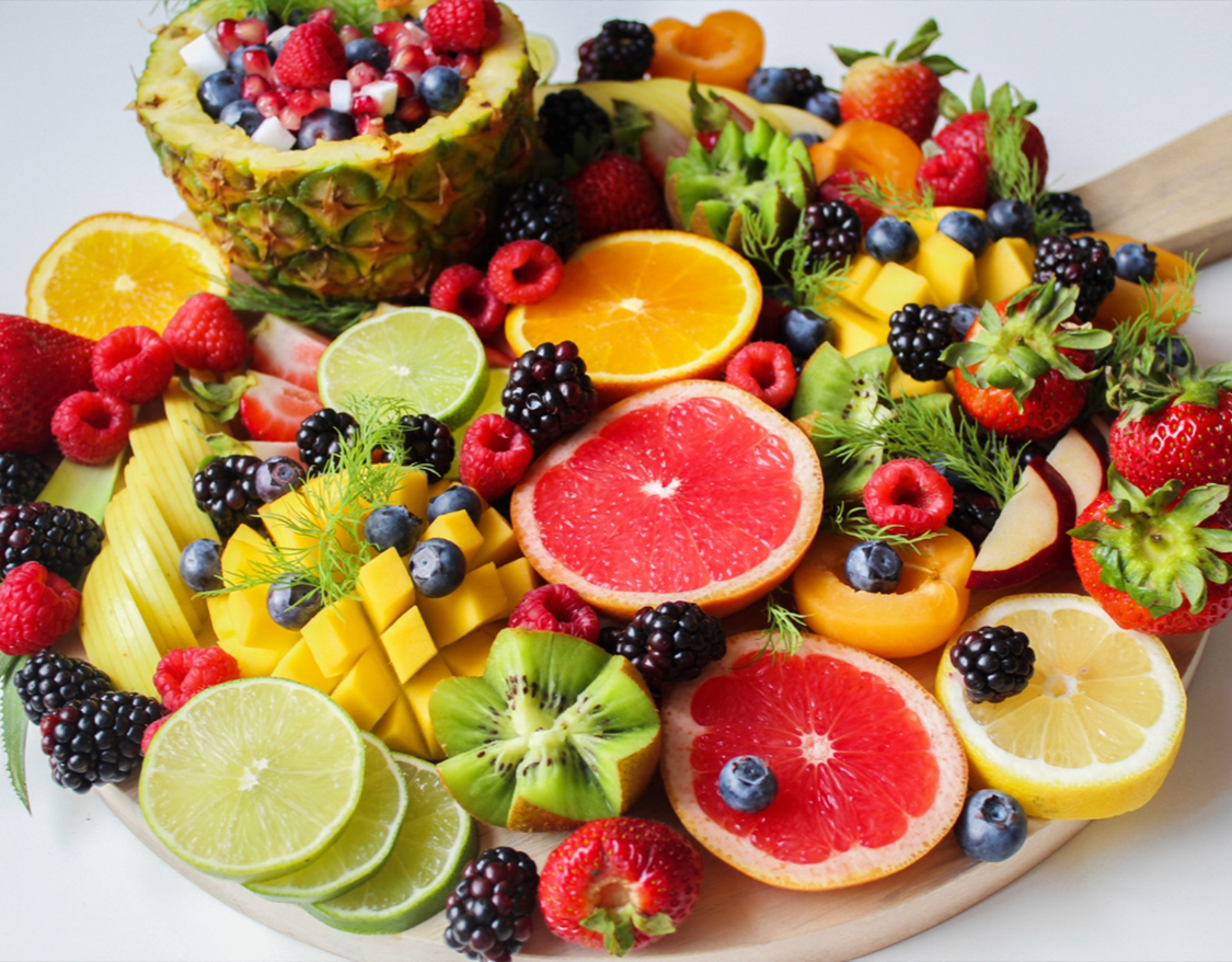 a plate of fruit on a white surface