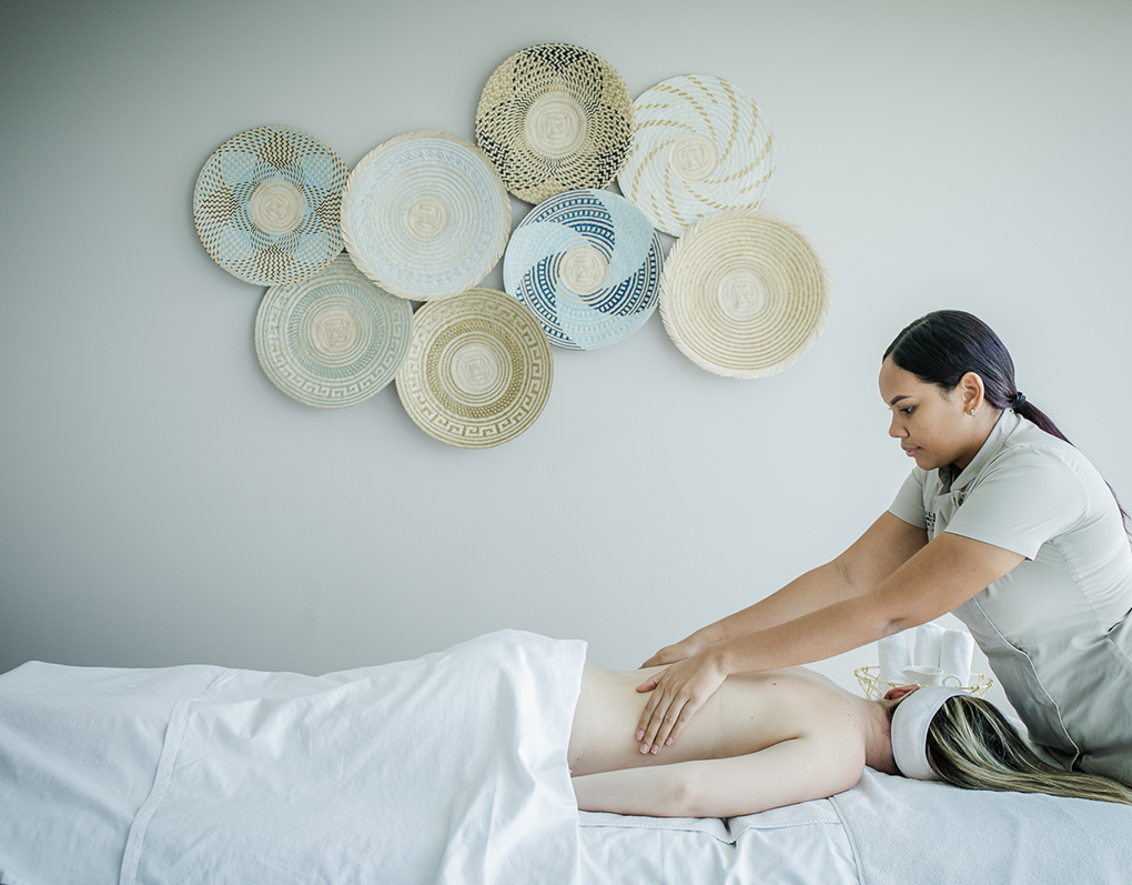 a woman sitting on a bed with a wall of paper plates