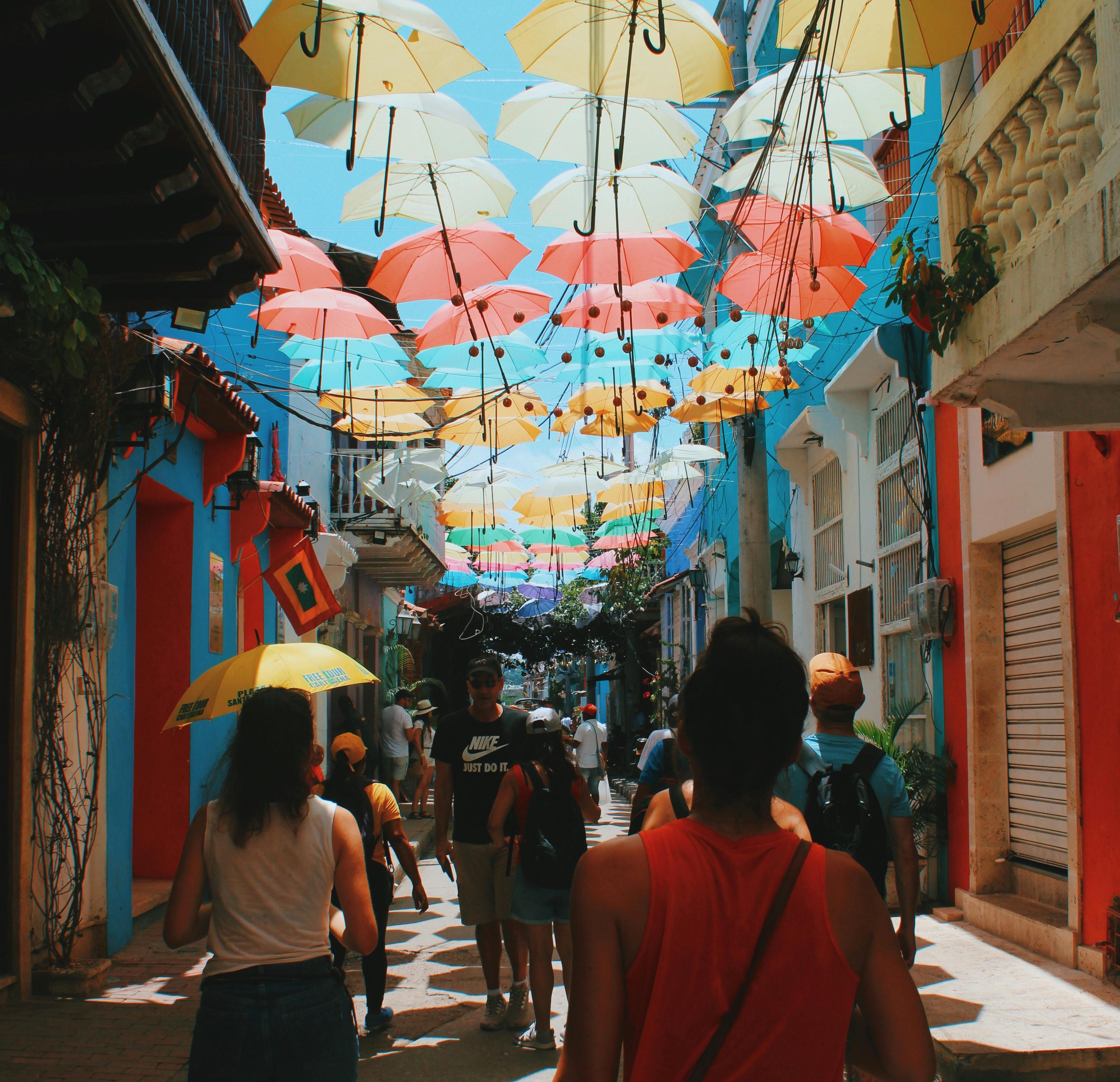 a group of people walking down a street with umbrellas