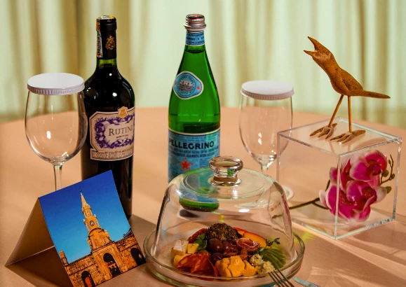 a table with a glass dish and wine bottles