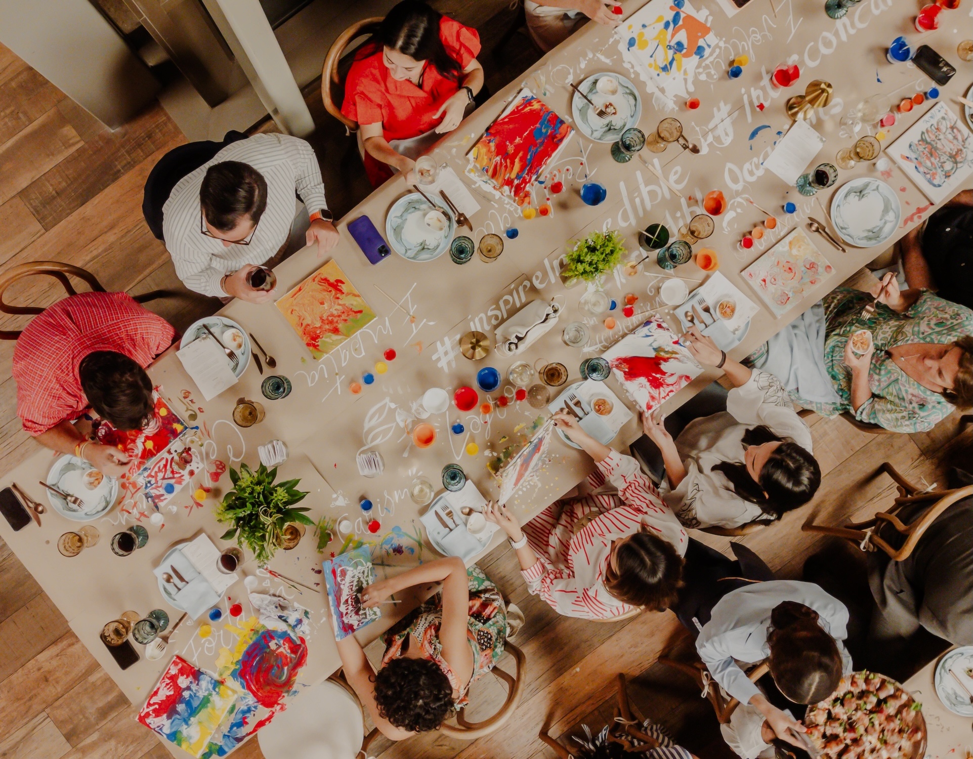 a group of people sitting around a table with food and drinks