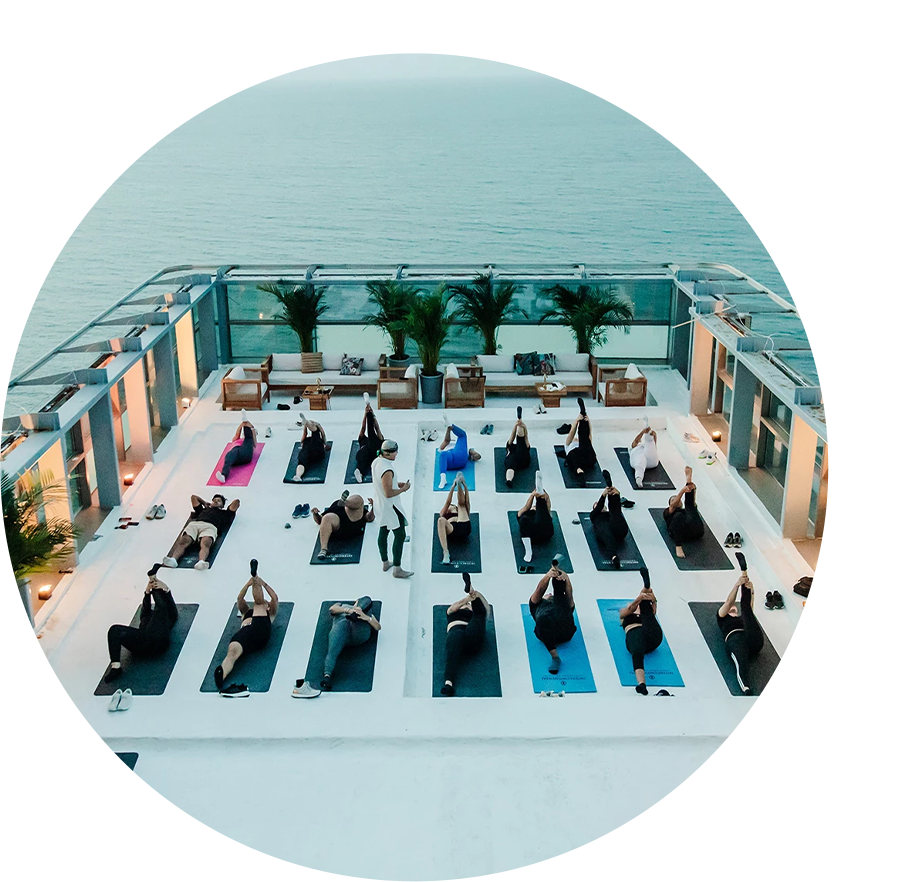 a group of people on mats on a rooftop overlooking water