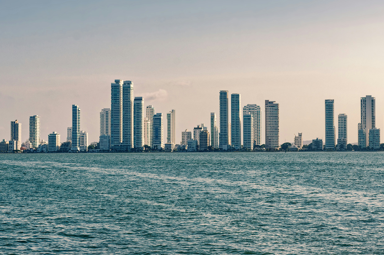 a city skyline with tall buildings and a body of water