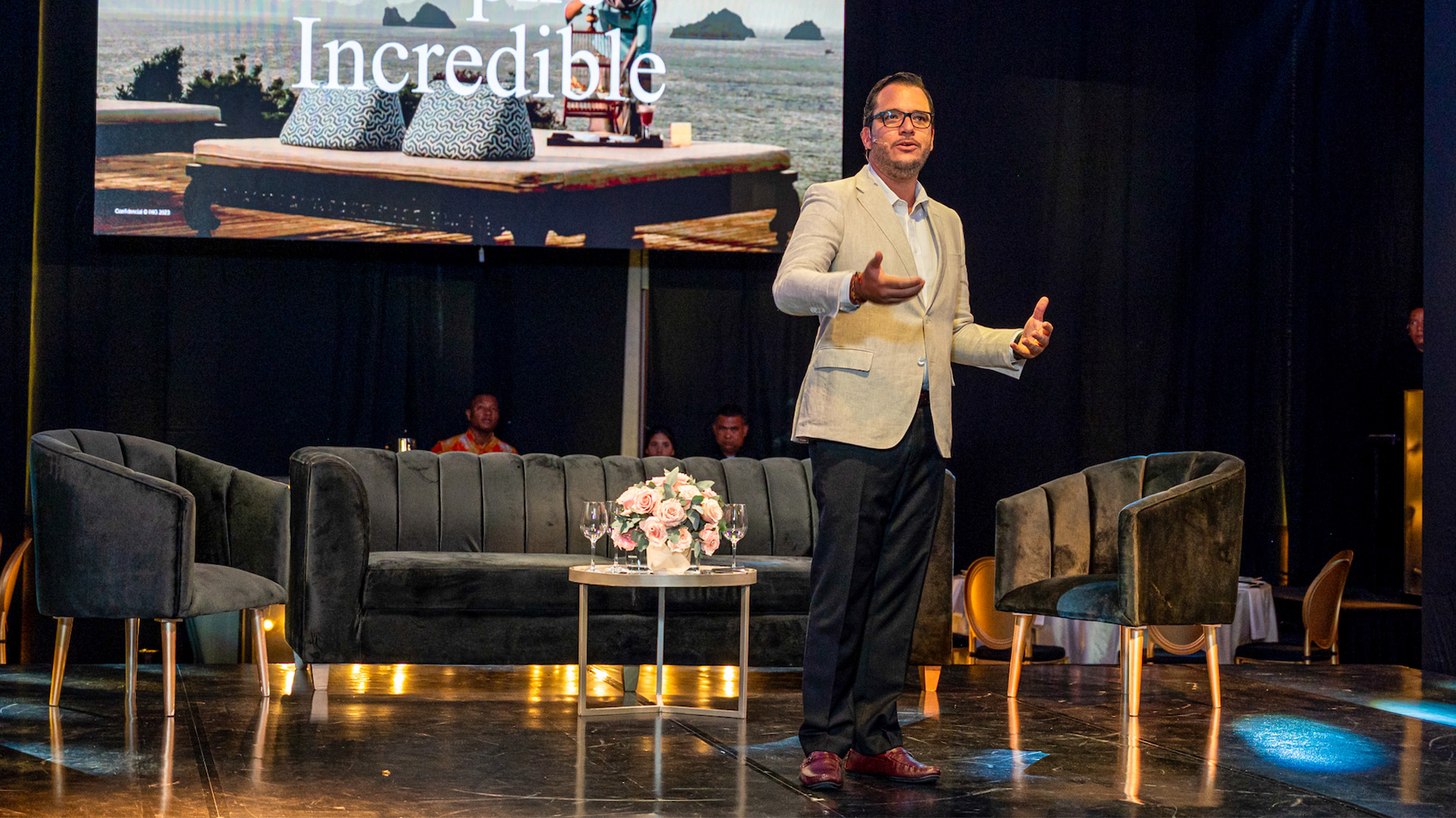 a man standing on a stage giving a thumbs up