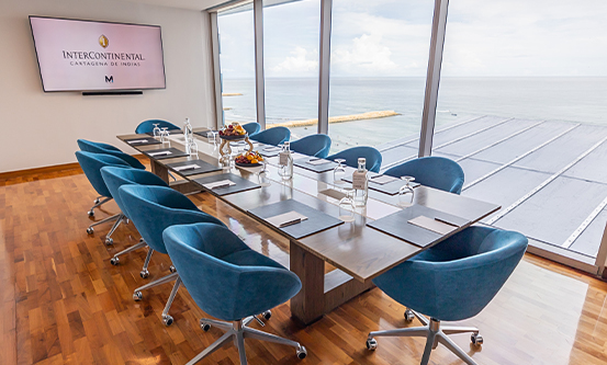 a table with blue chairs and a large screen