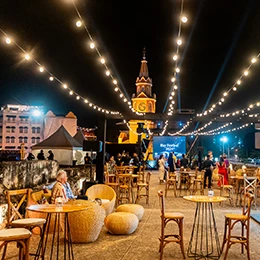 a group of people sitting at tables and chairs in a courtyard