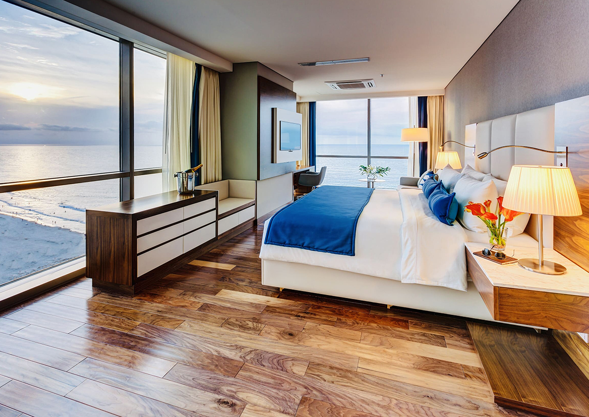 a bedroom with a large window overlooking the ocean