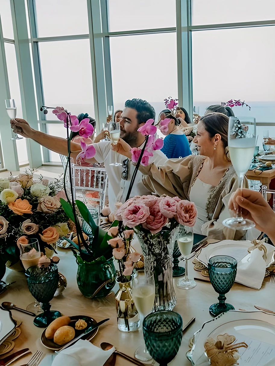 a group of people at a table with flowers and glasses