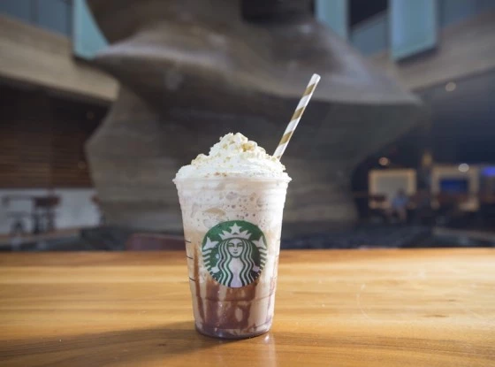 a cup of coffee with whipped cream and straw
