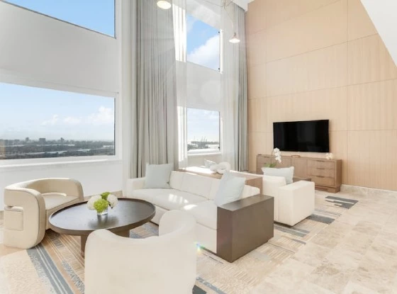 a living room with a large window, a tv and upholstered furniture