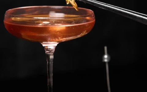 a pair of chopsticks holding a glass of liquid