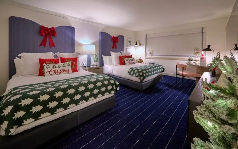 a room with two beds and a table with a red bow