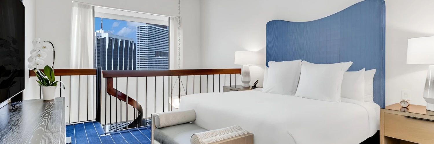 a bed with a lamp and a bench in a room