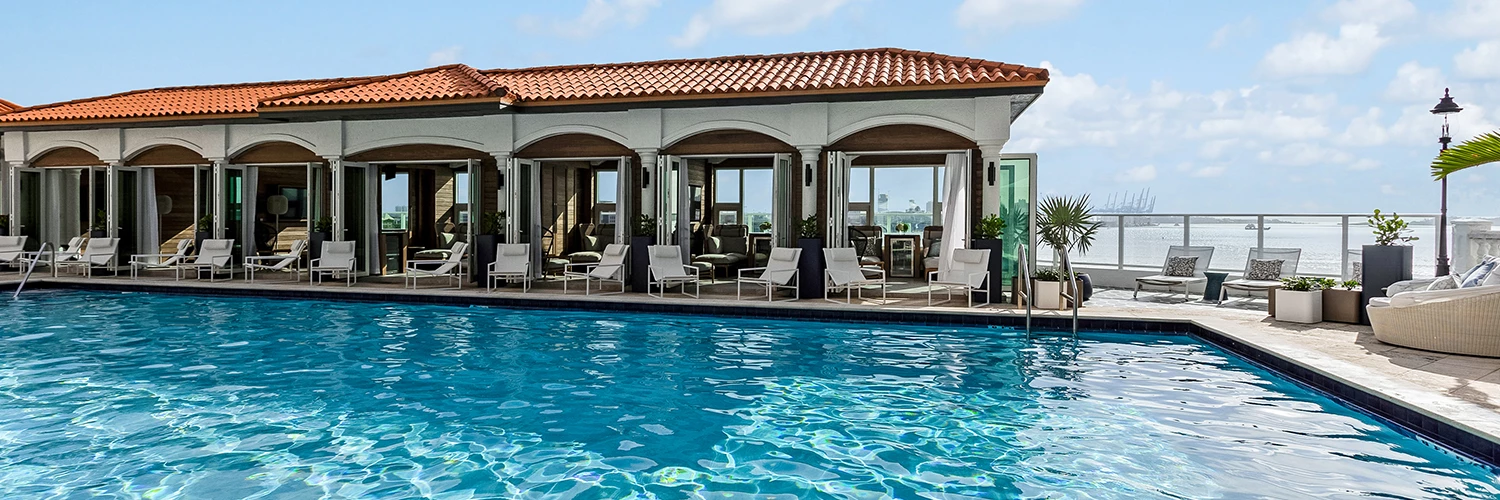 An accommodation with a  swimming pool with chairs around it